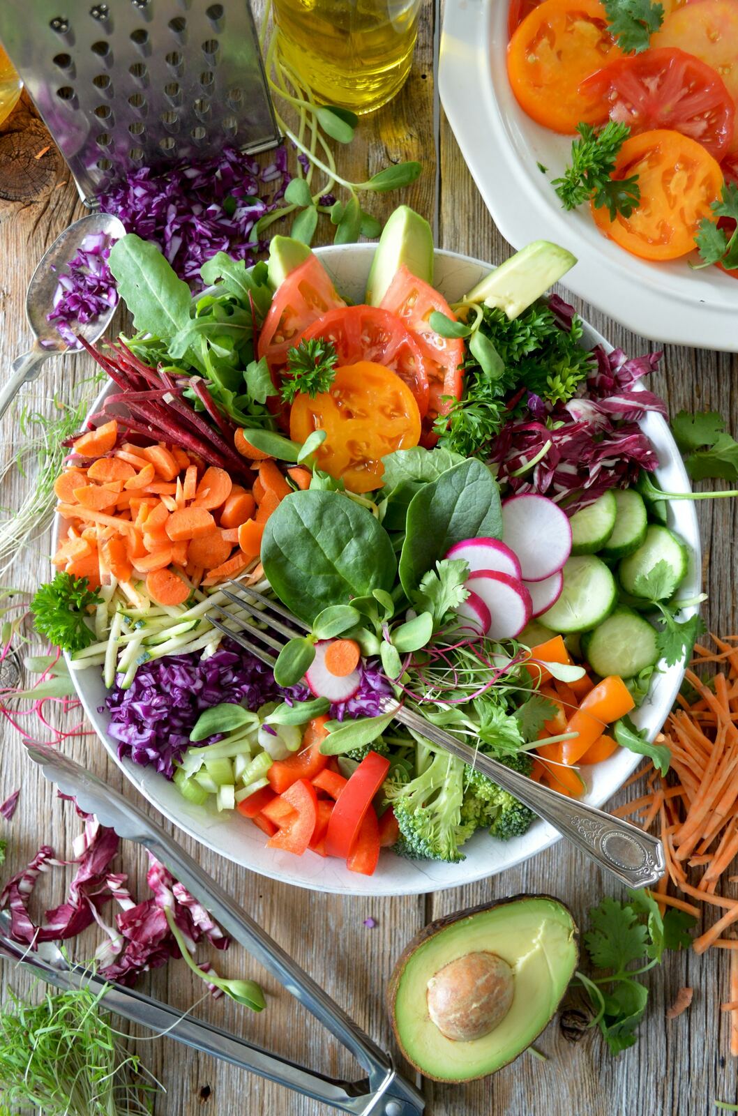 A bowl of salad with tomato, radish, cucumber, red cabbage, carrot and herbs