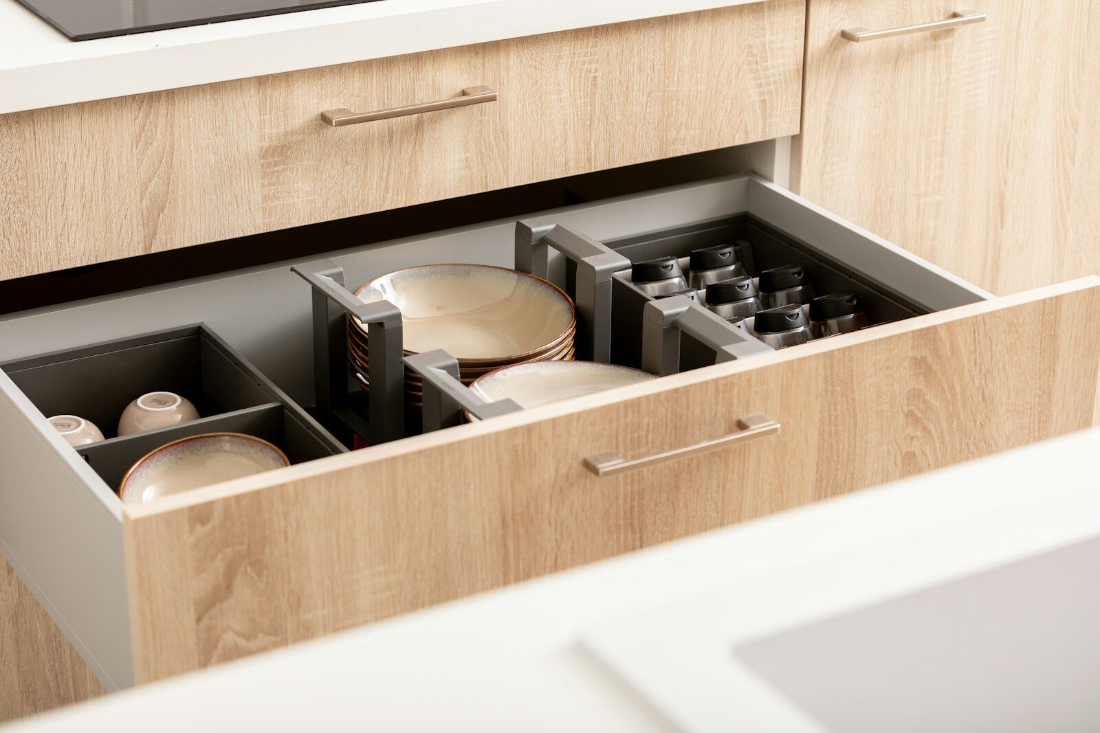 An open kitchen drawer with plates and bowls held in neat dividers
